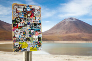 BOPP stickers covering the back of a street sign with a lake and mountain in the background